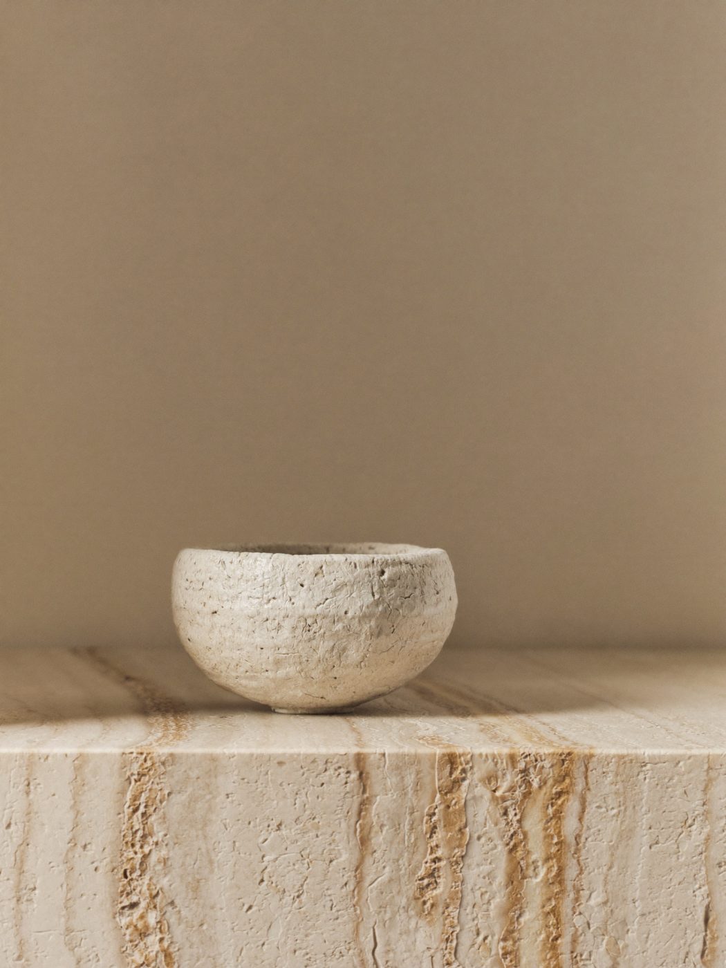 A handmade ceramic bowl on warm stone